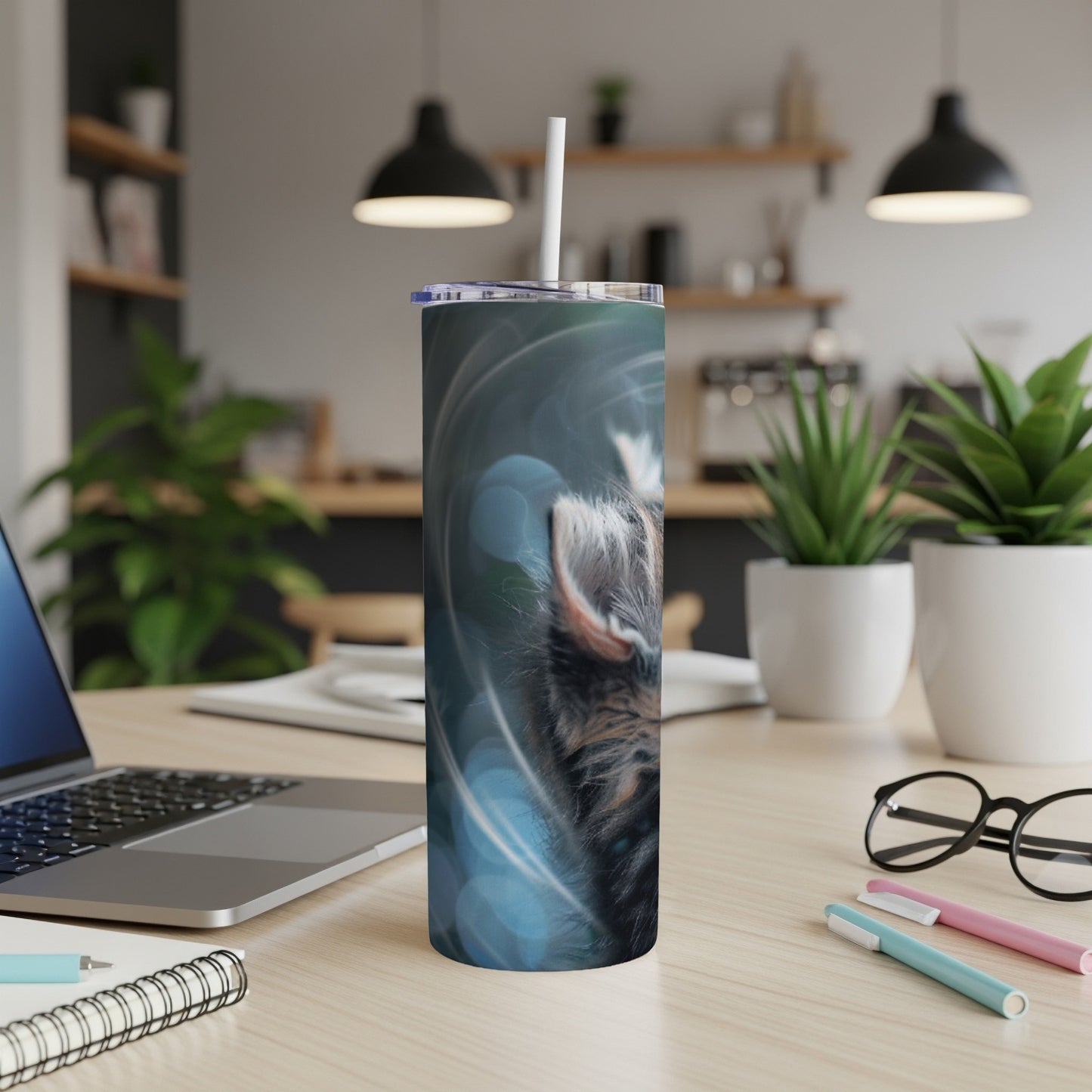 Close-up of a cat's face on a blue swirl tumbler with a straw.