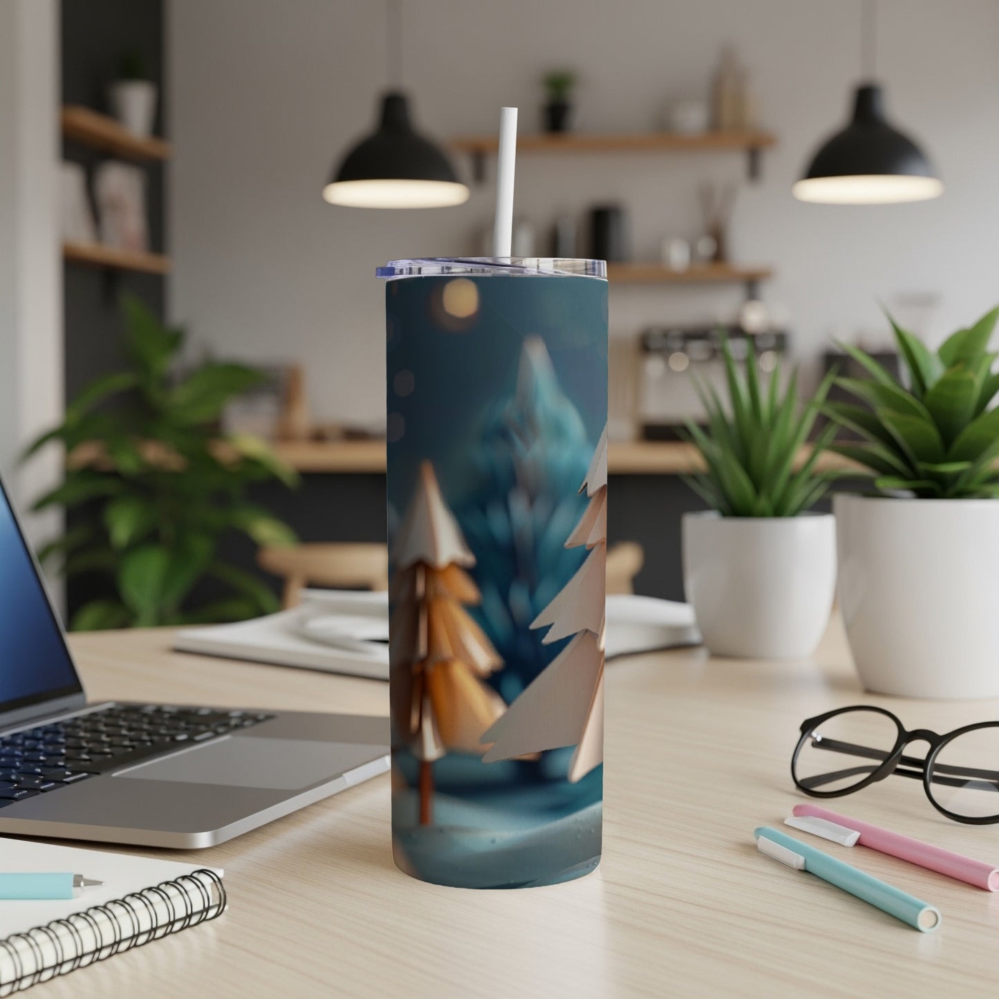 Paper Christmas trees on a blue, snowy background on a stainless steel tumbler.