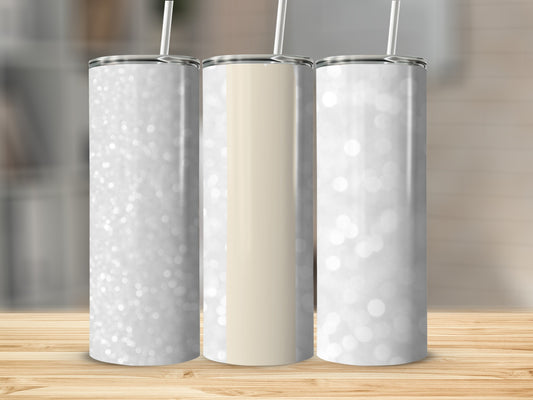 Three glitter tumblers with straw on a wooden surface.