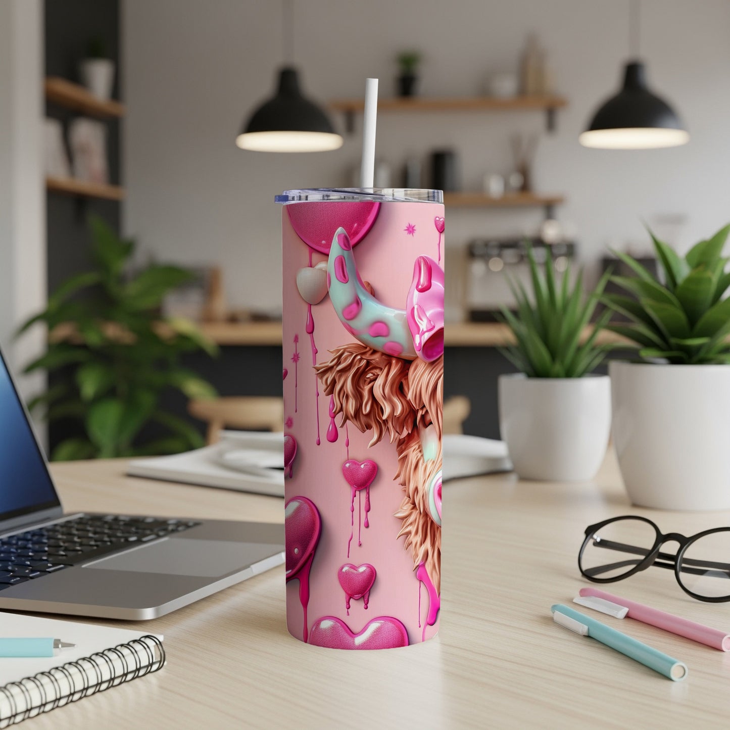 Pink tumbler with cow print and heart details, a straw protruding.