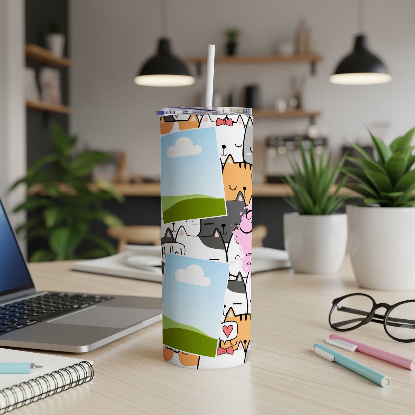Tumbler with a cartoon cat pattern and two framed photos.