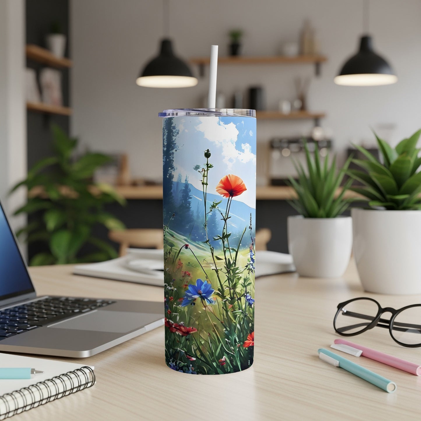 Floral skinny tumbler with poppies and wildflowers, displayed on a desk.