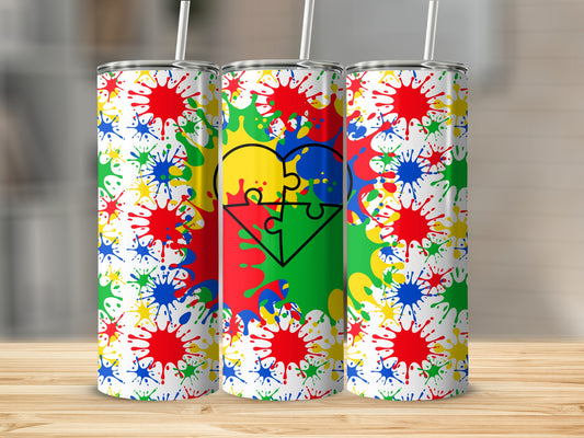 Three tumblers with colorful paint splatters and autism puzzle heart design.