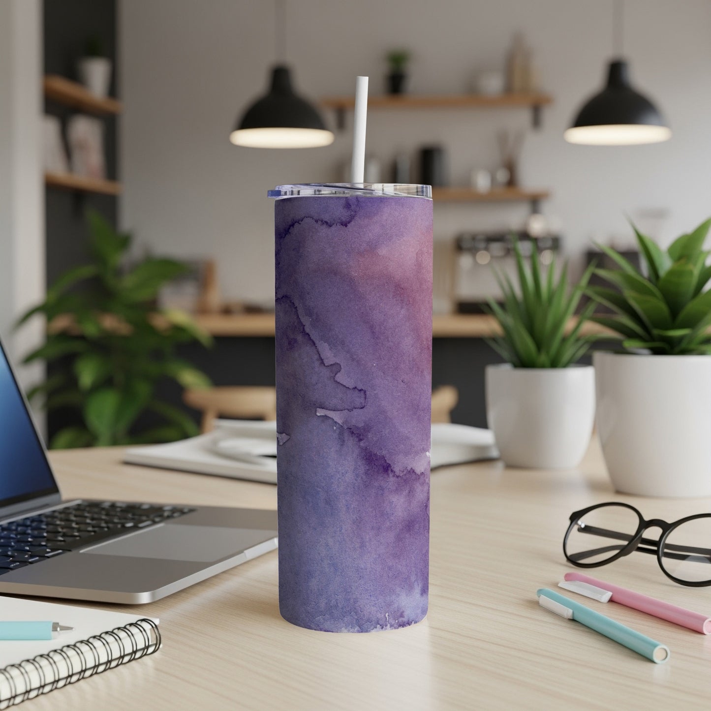 Purple watercolor tumbler with white straw on a desk.