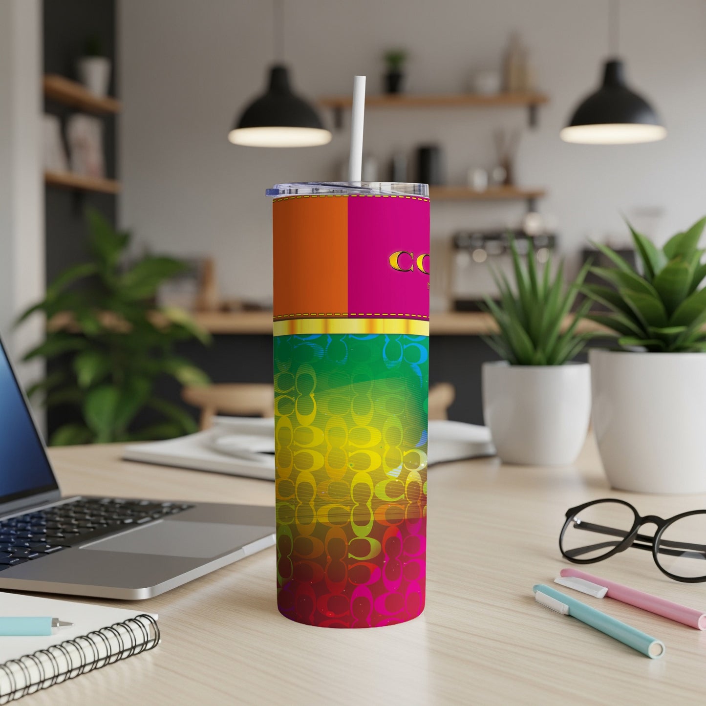 Tall tumbler with colorful geometric pattern and repeating logos on desk.