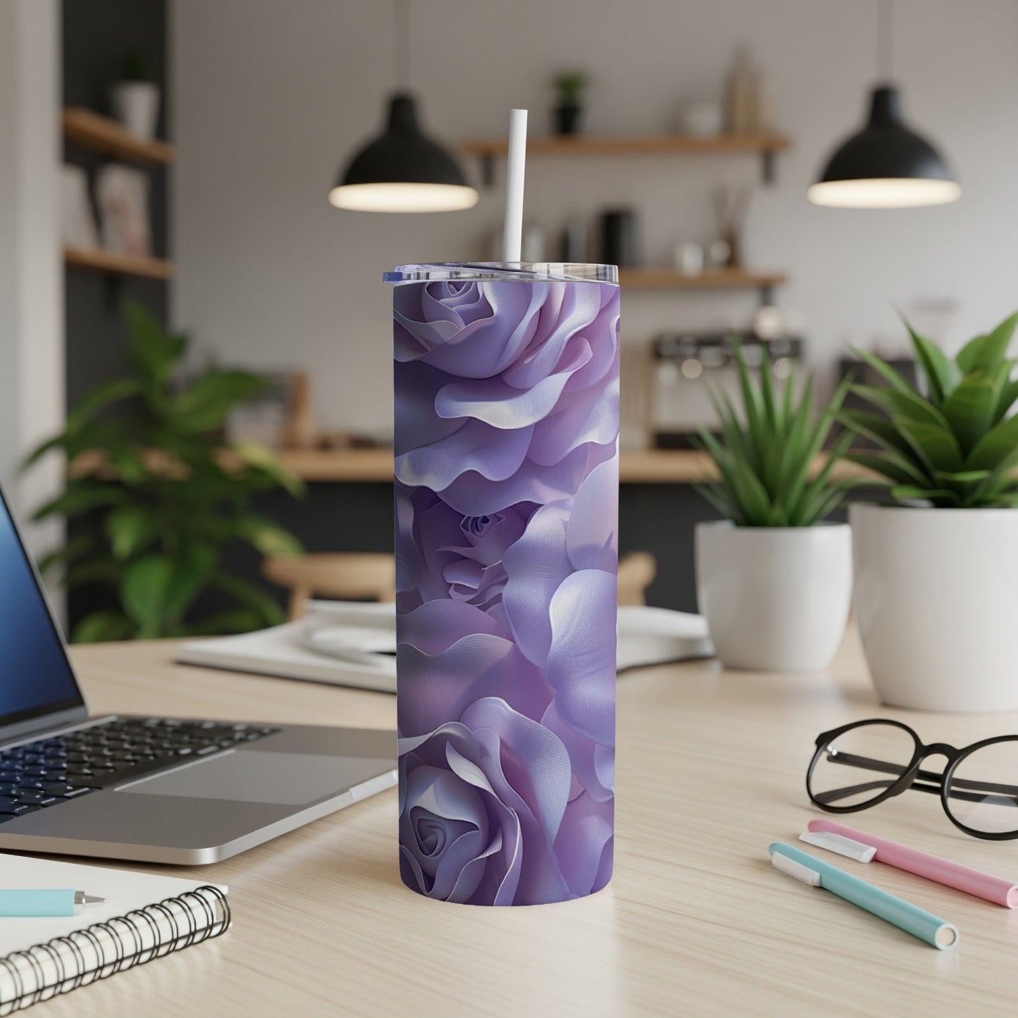Purple floral patterned tumbler with white lid and straw on desk.