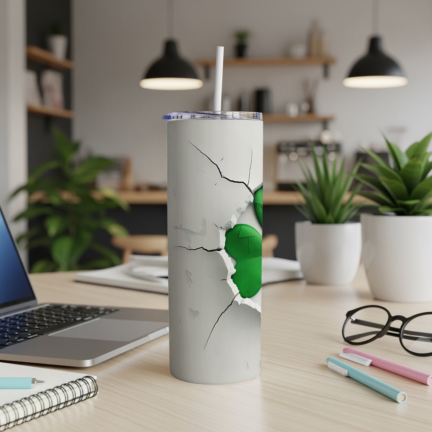 White tumbler with cracked design revealing green inside, straw inserted.