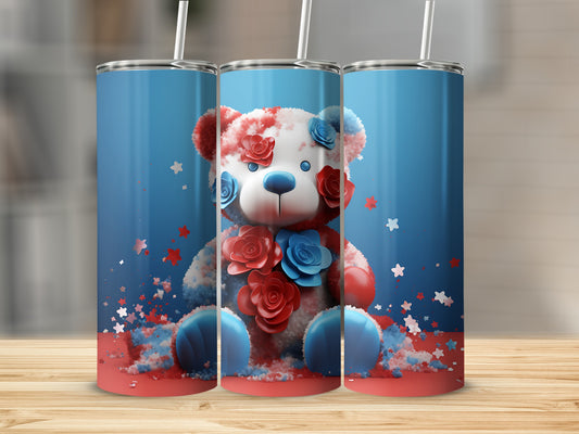 Fuzzy teddy bear with red and blue flowers on a patriotic background.