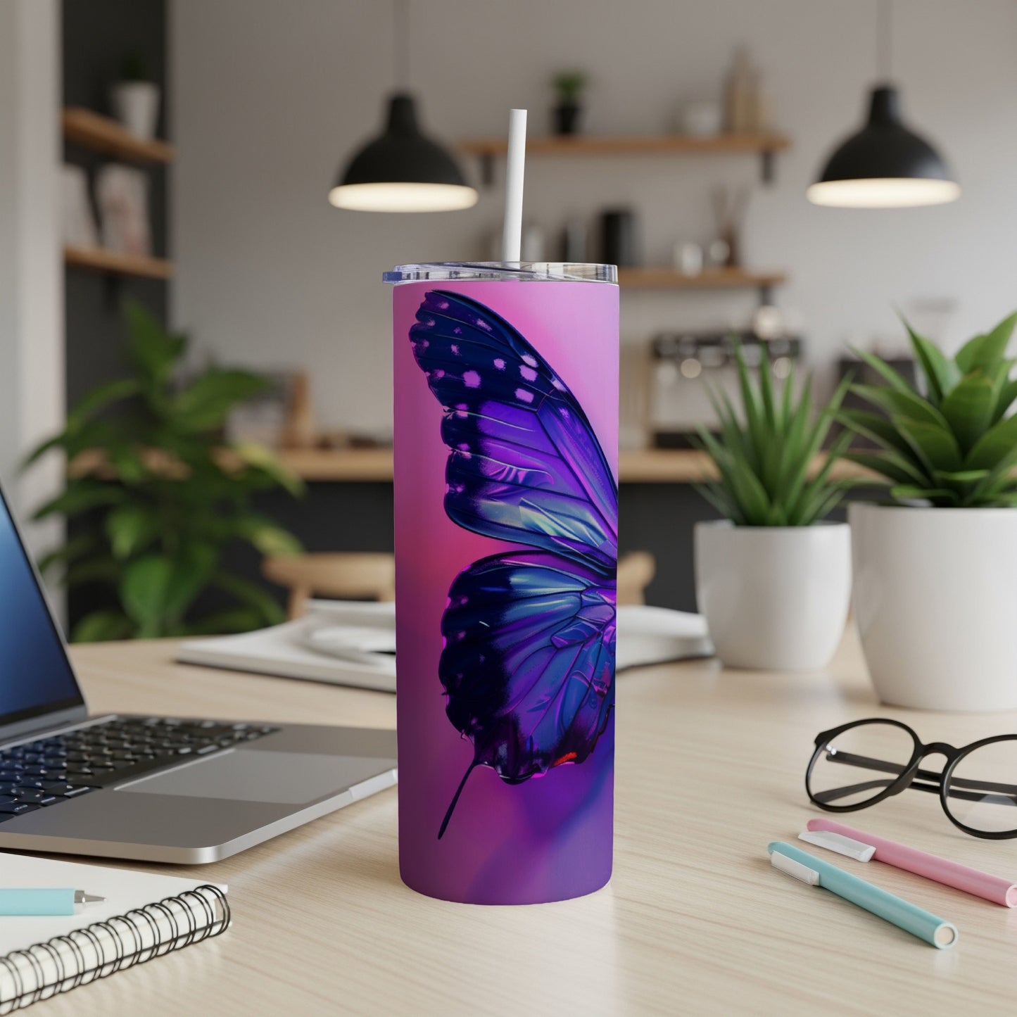 Purple butterfly design on a pink tumbler with a straw.
