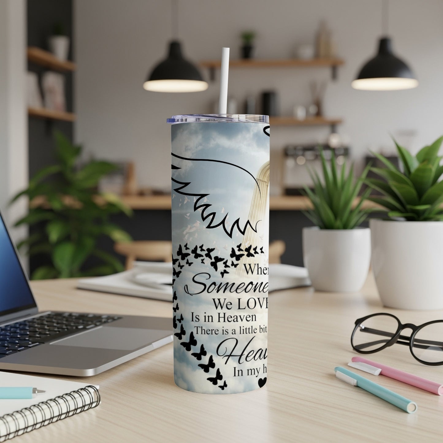 Tall tumbler with angel wings and a flock of butterflies, text reads "When Someone We Love Is in Heaven".