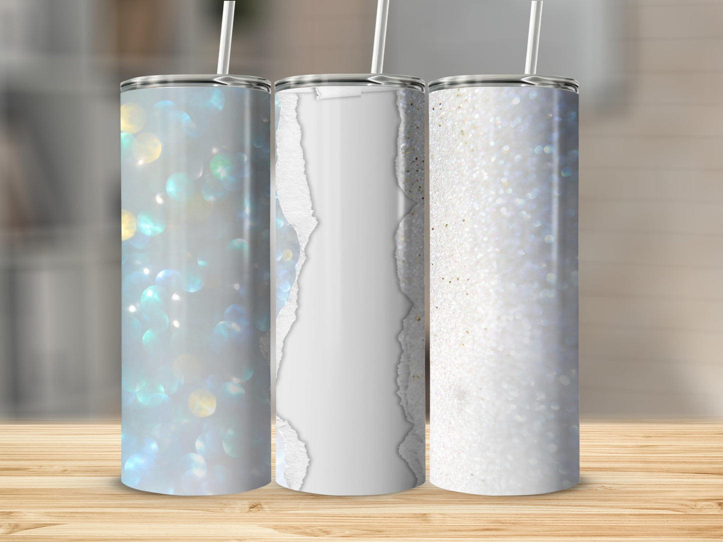 Three tumblers with glittery and ripped paper designs on a wooden surface.