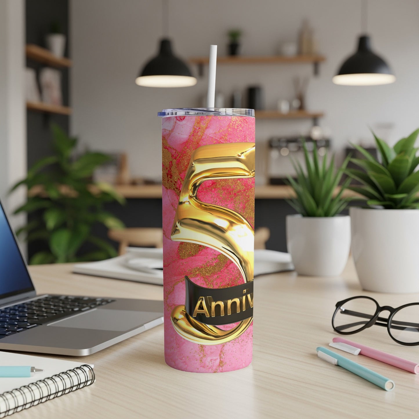 Pink marble tumbler with gold "5" and "Anniv" text on a desk.