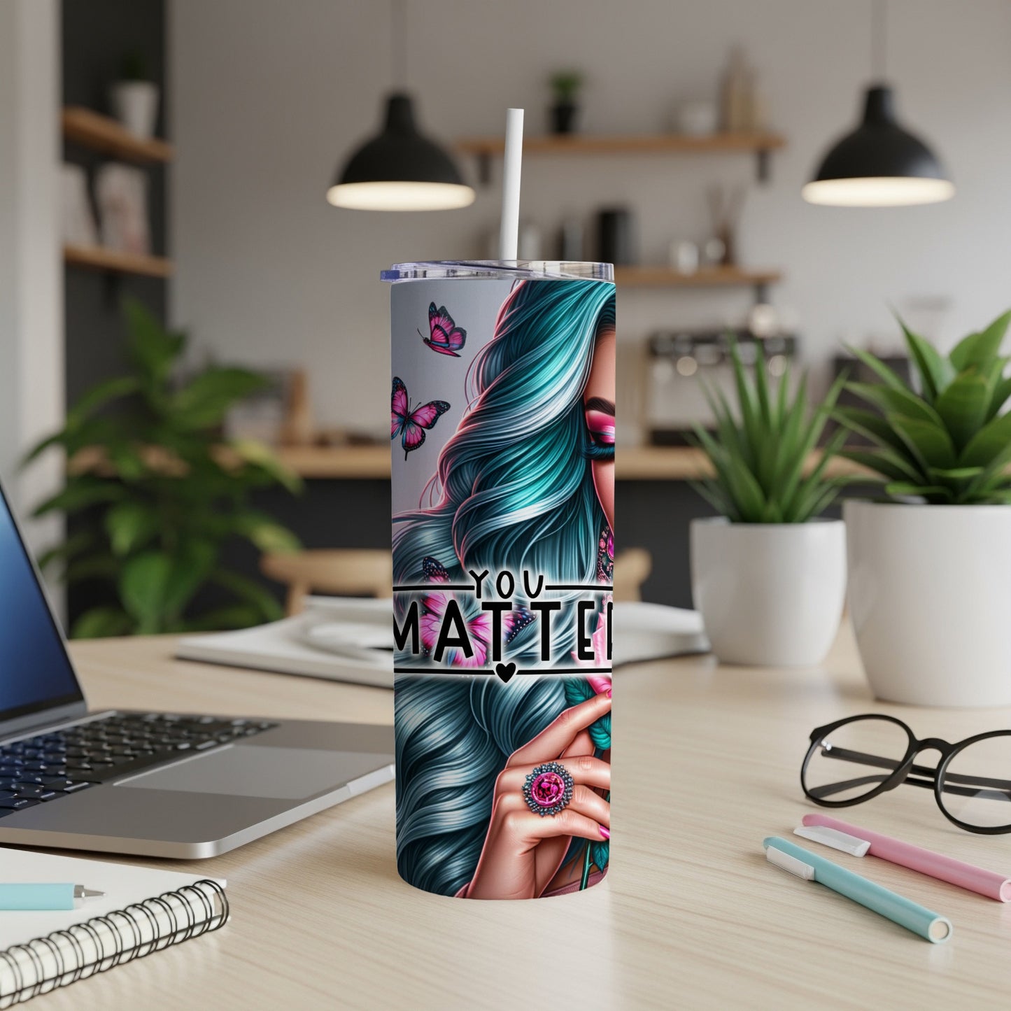 Woman with teal hair and butterflies, "You Matter" text on tumbler.
