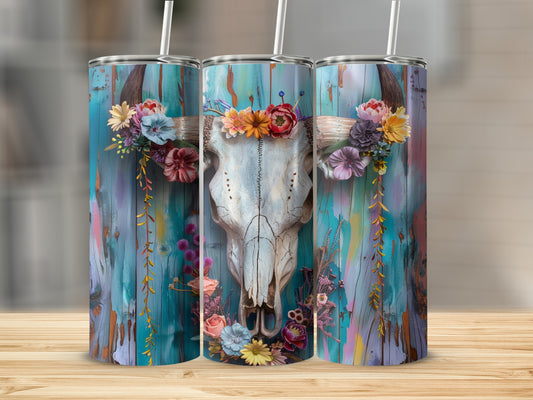 Skull with floral crown and garland on teal wood background.