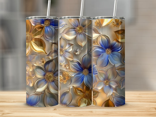 Three floral tumblers with blue and gold embossed flowers on a wooden surface.