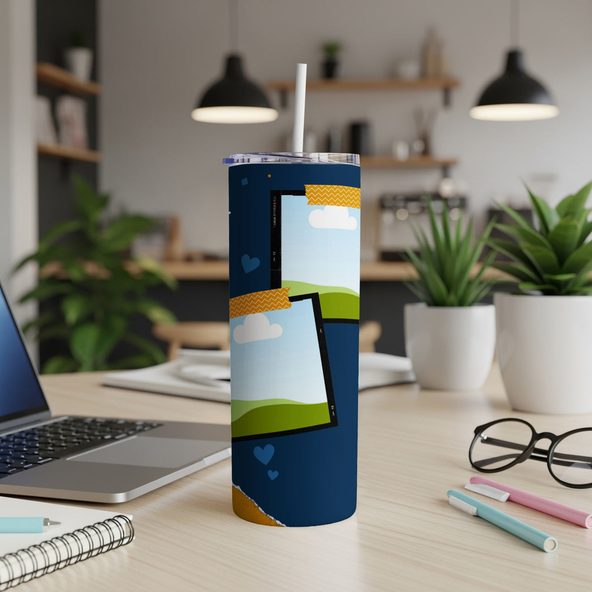 Tumbler with photos of clouds, hills, and hearts on a dark blue background.