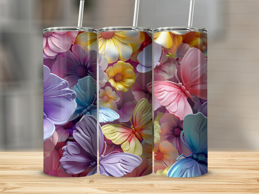 Three tumblers with floral and butterfly designs displayed on a wooden surface.