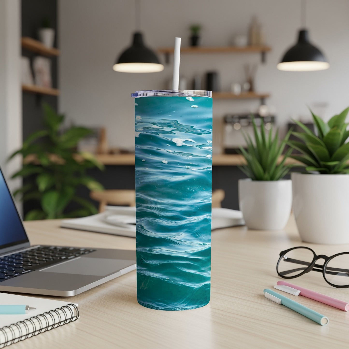 Blue water waves pattern on a tall, insulated tumbler on a desk.