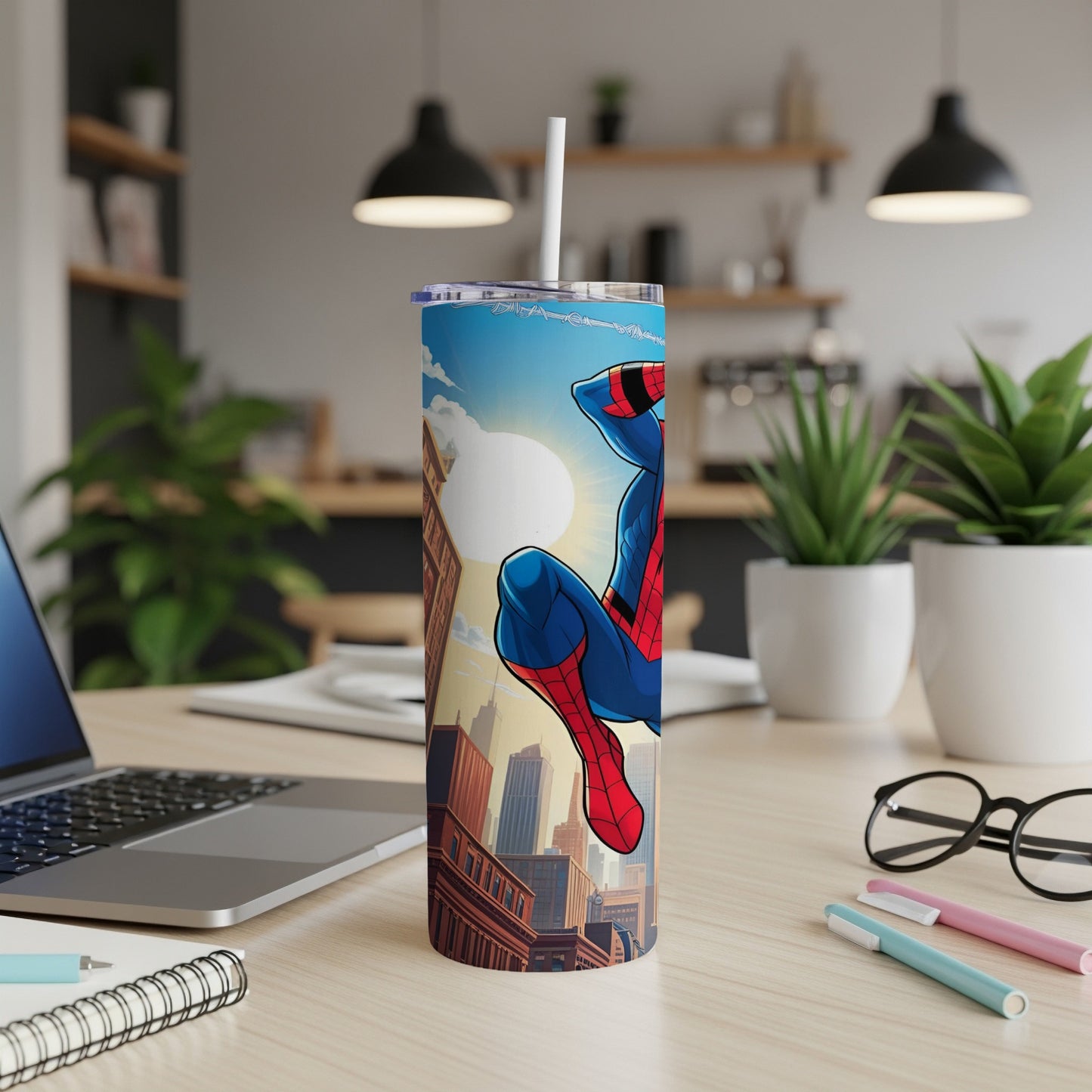 Spider-Man on a cityscape tumbler with straw, on a desk.