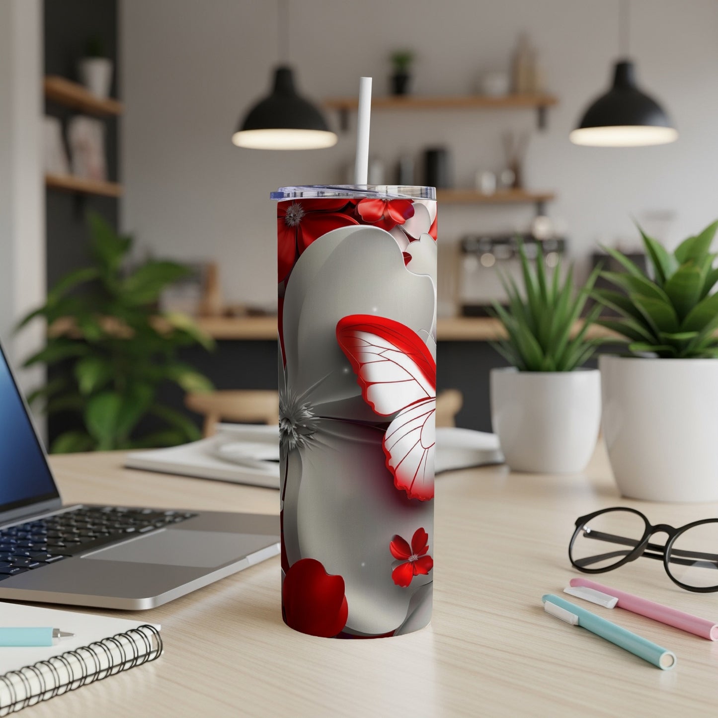 Red butterfly and floral design on a white insulated tumbler.