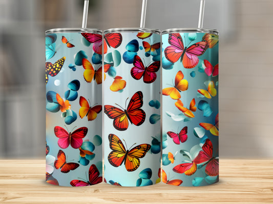 Three tumblers with colorful butterfly designs stand on a wooden surface.