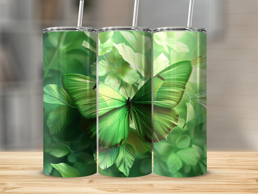 Green butterfly on lush green leaves, three tumblers displayed.
