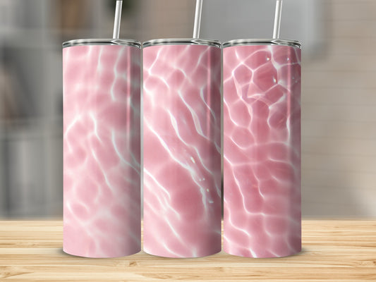 Three pink tumblers with water ripple design on wooden surface.