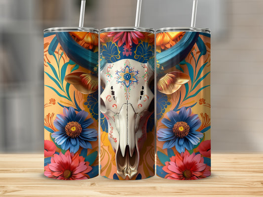 Cow skull with floral embellishments on a colorful, ornate tumbler.