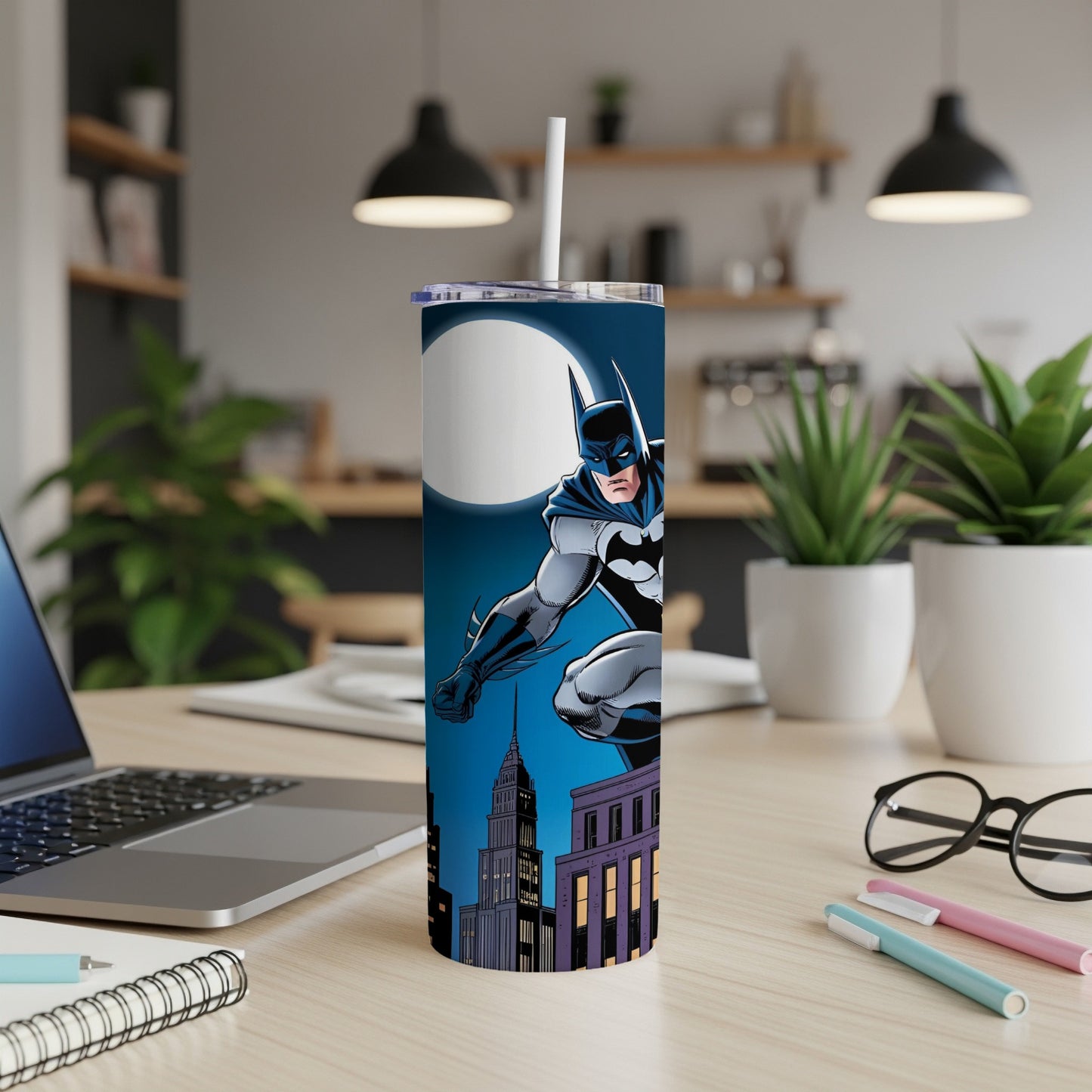 Batman leaping in front of a city skyline on a blue insulated tumbler.