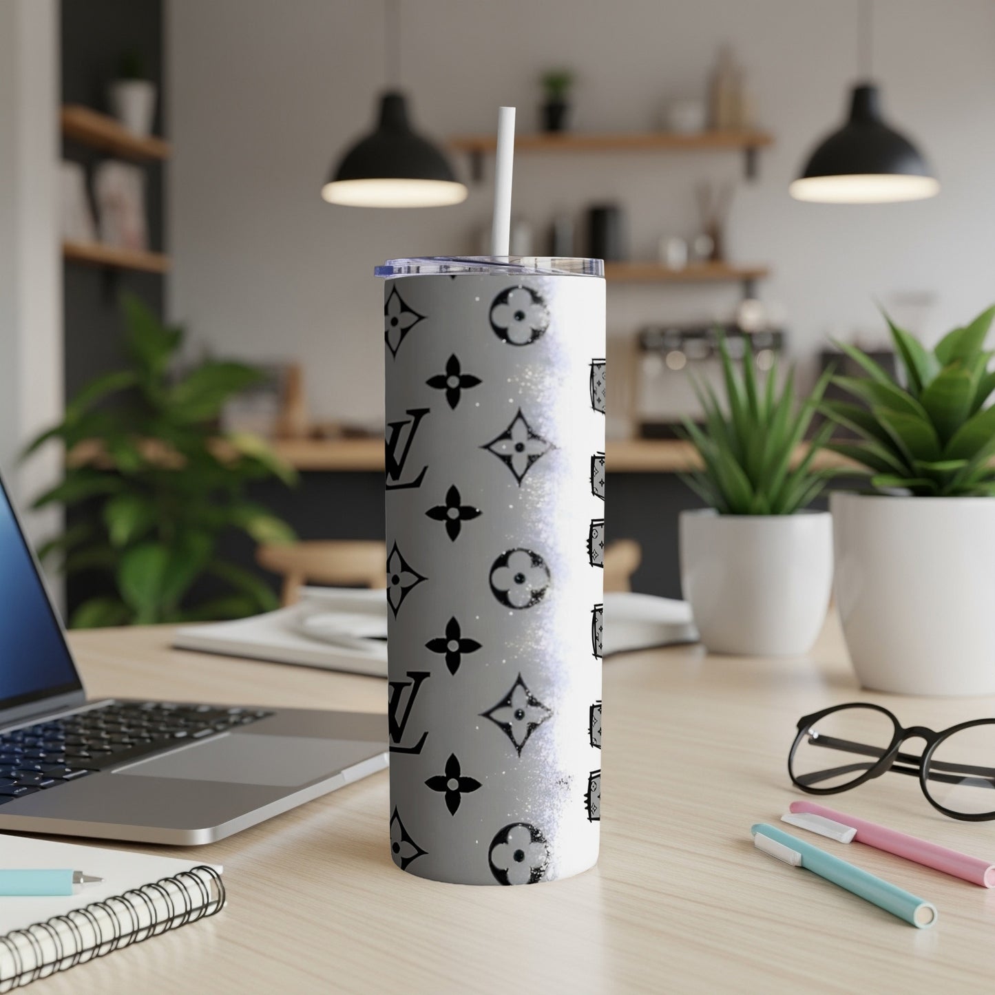 White tumbler with repeating black LV monogram pattern and straw.