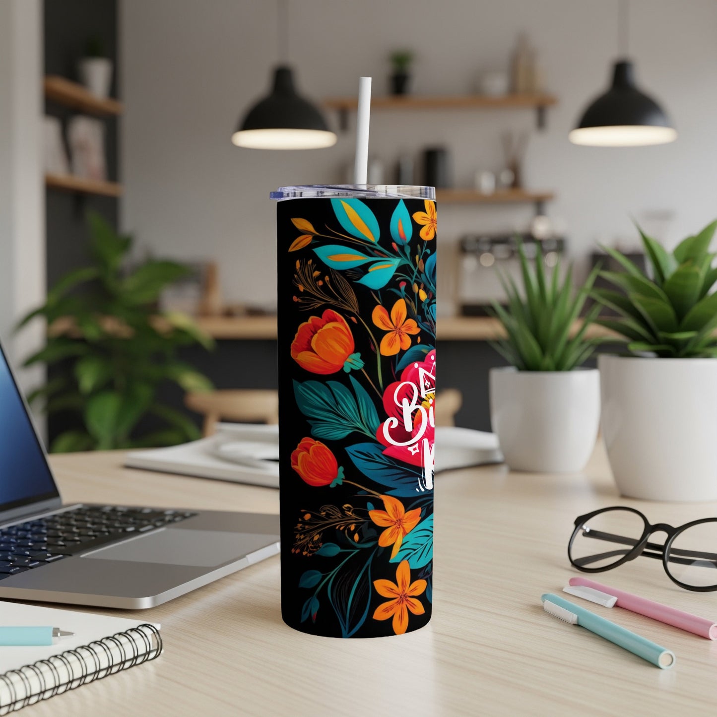 Black tumbler with colorful floral pattern and white straw.