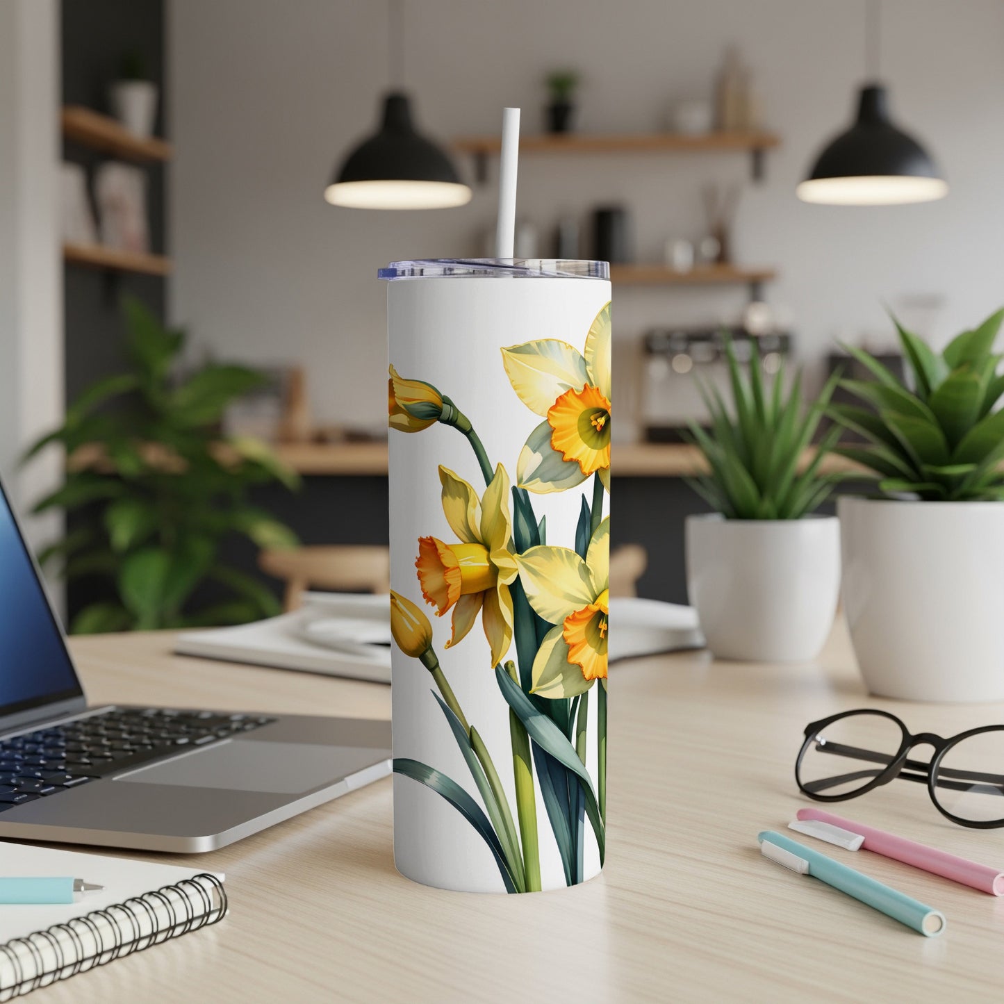 White tumbler with a pattern of yellow daffodils and green leaves.