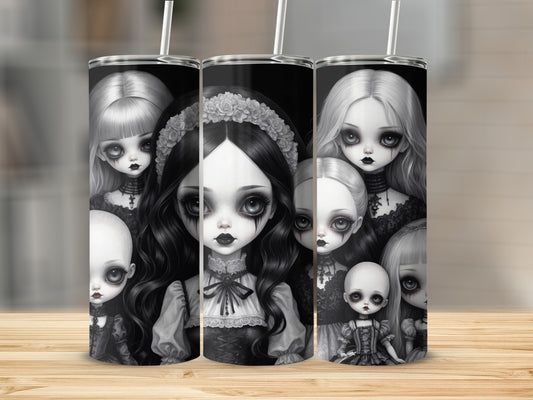 Collection of gothic dolls with pale skin and dark hair on a wooden surface.