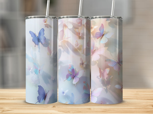 Three tumblers with a watercolor butterfly design displayed on a wooden surface.