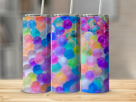 Three colorful, translucent orbs fill three tumblers with straws.