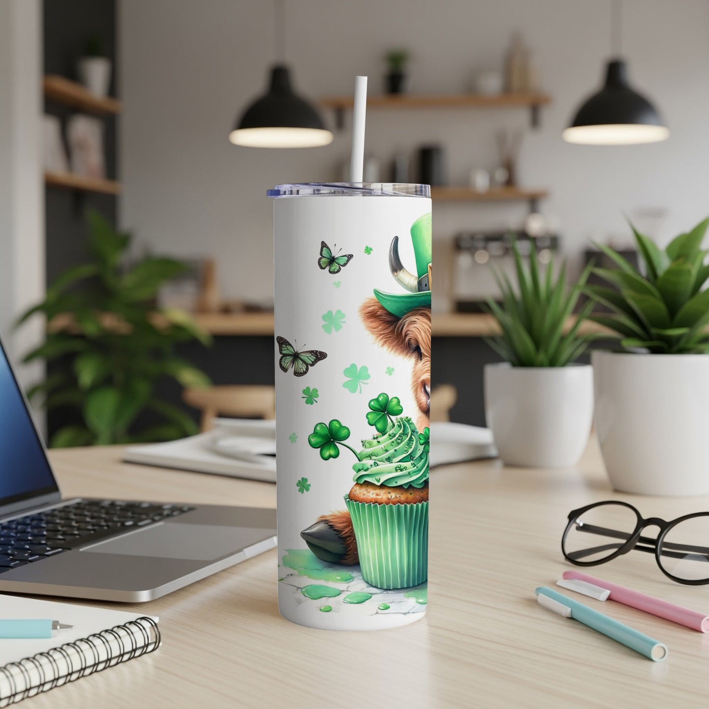 Tall tumbler featuring a cow wearing a St. Patrick's Day hat with a cupcake and shamrocks.