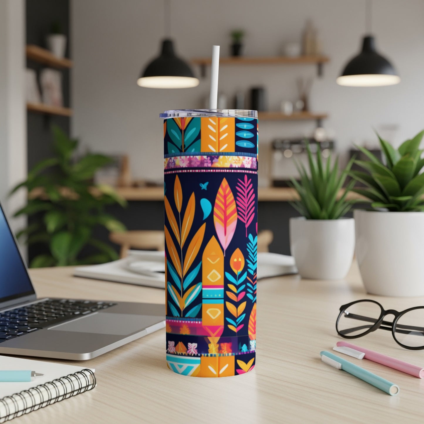 Abstract floral and geometric pattern on a tall, insulated tumbler with straw.