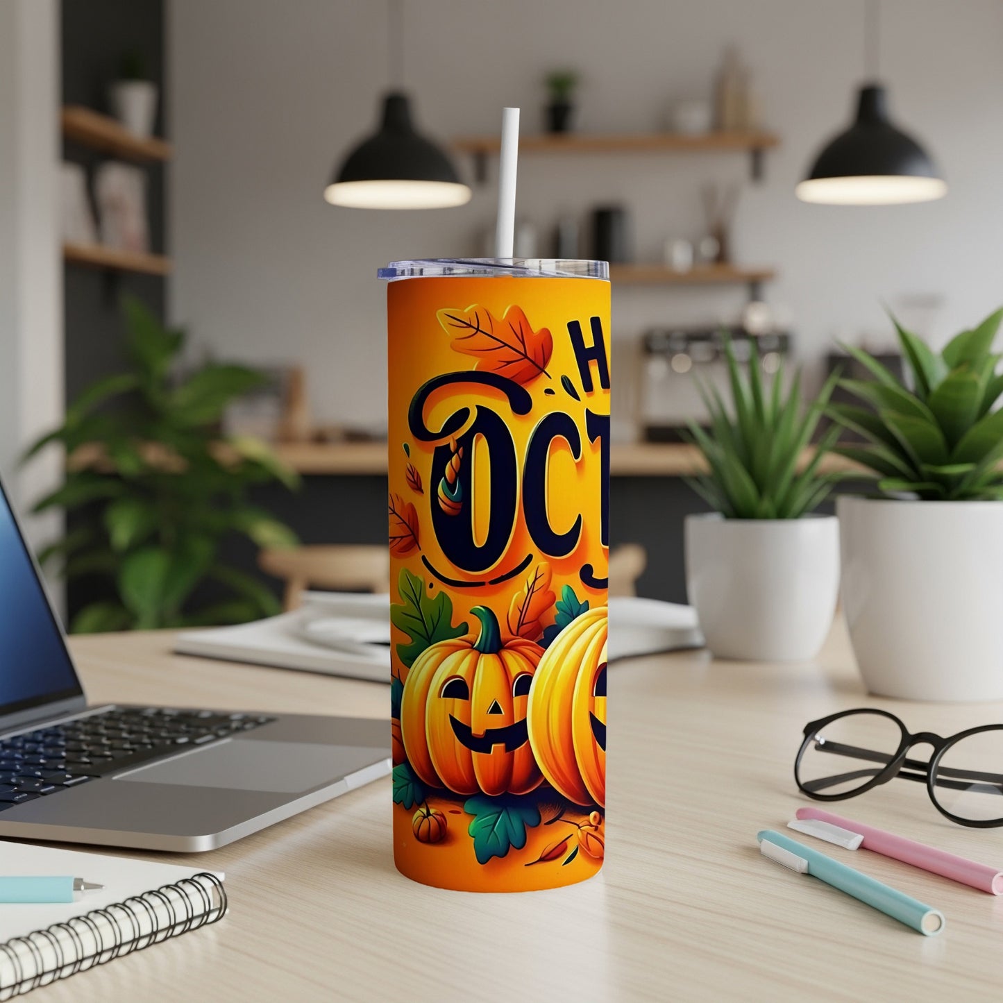 Orange tumbler with "Happy October" text and smiling pumpkins, set on a desk.