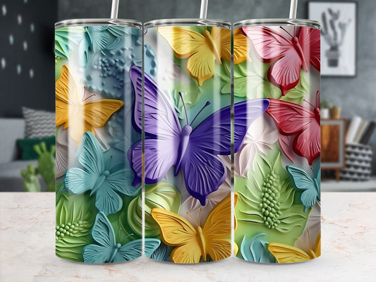 Three tumblers with colorful butterfly and floral embossed designs.