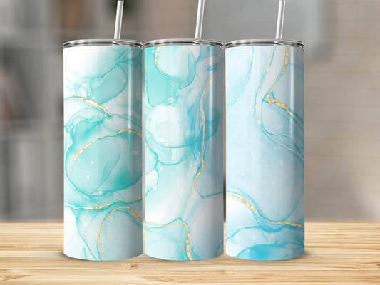 Three tumblers with abstract blue and gold marbled design on a wooden surface.