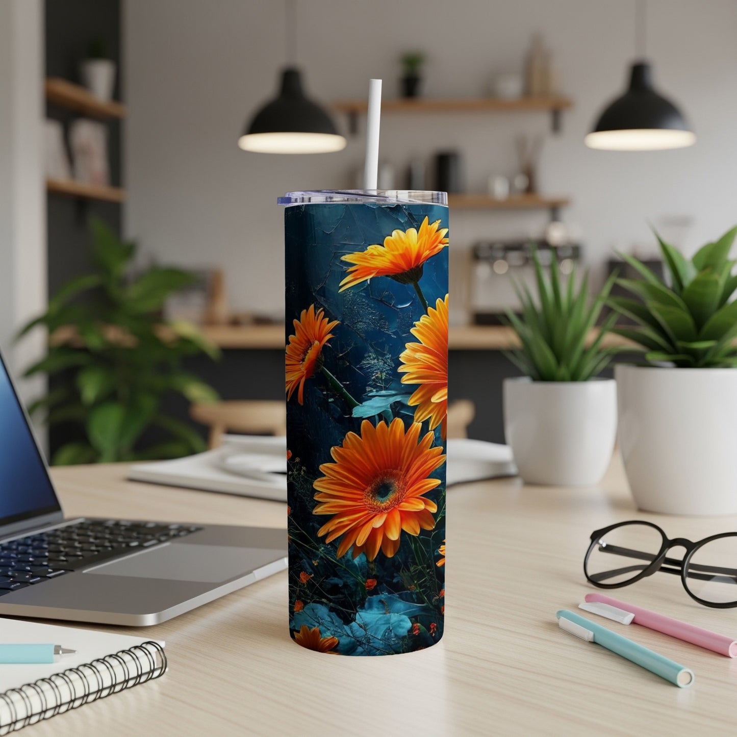 Tall tumbler with orange flowers and green leaves on a dark blue background.