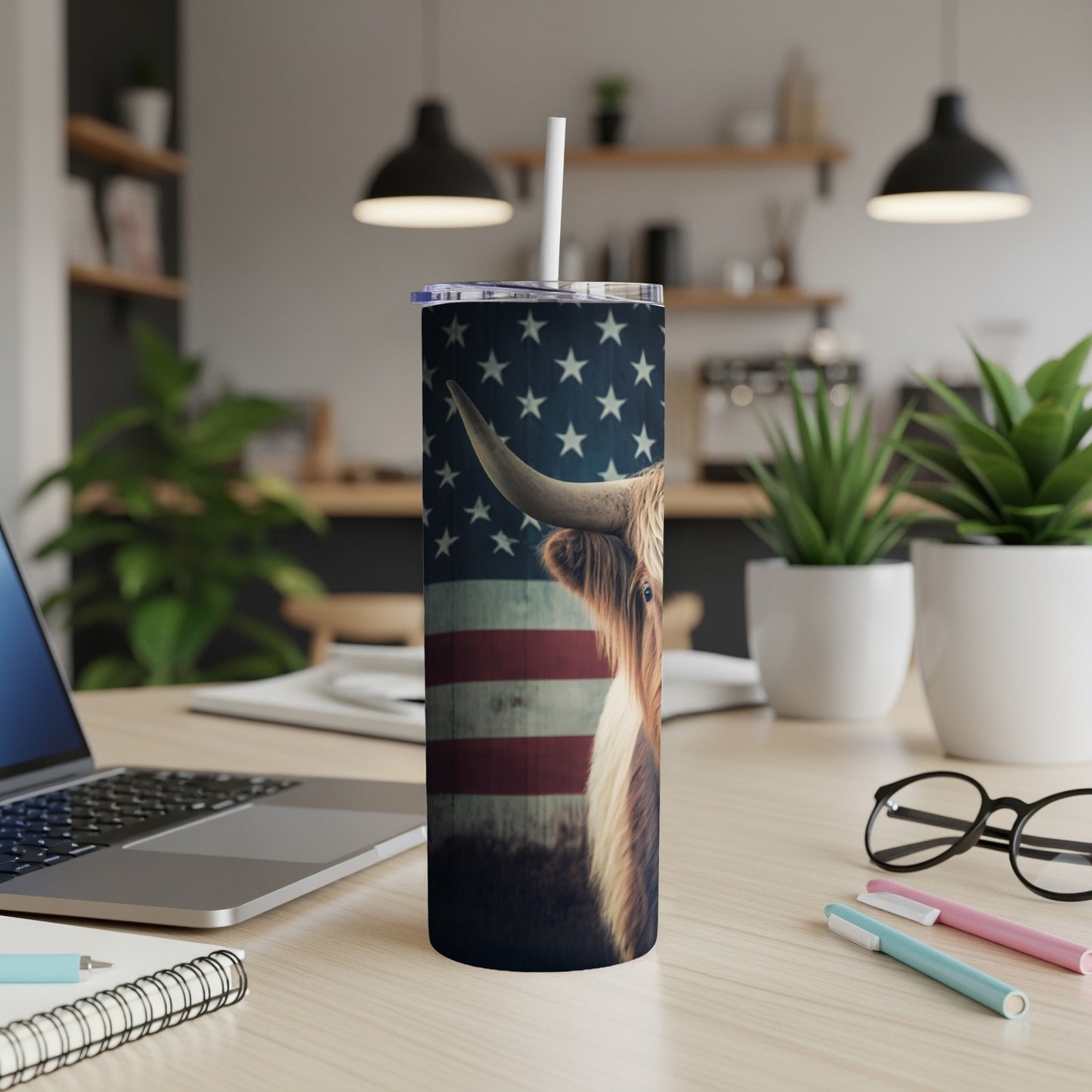 Highland cow with American flag pattern on a white tumbler with a straw.