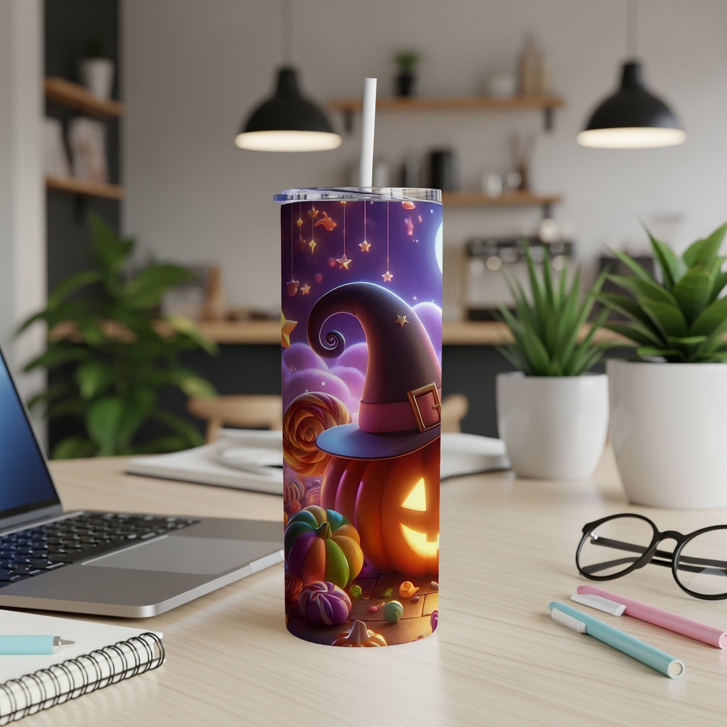 Halloween tumbler with witch hat, pumpkin, candy, and stars design on a wooden desk.