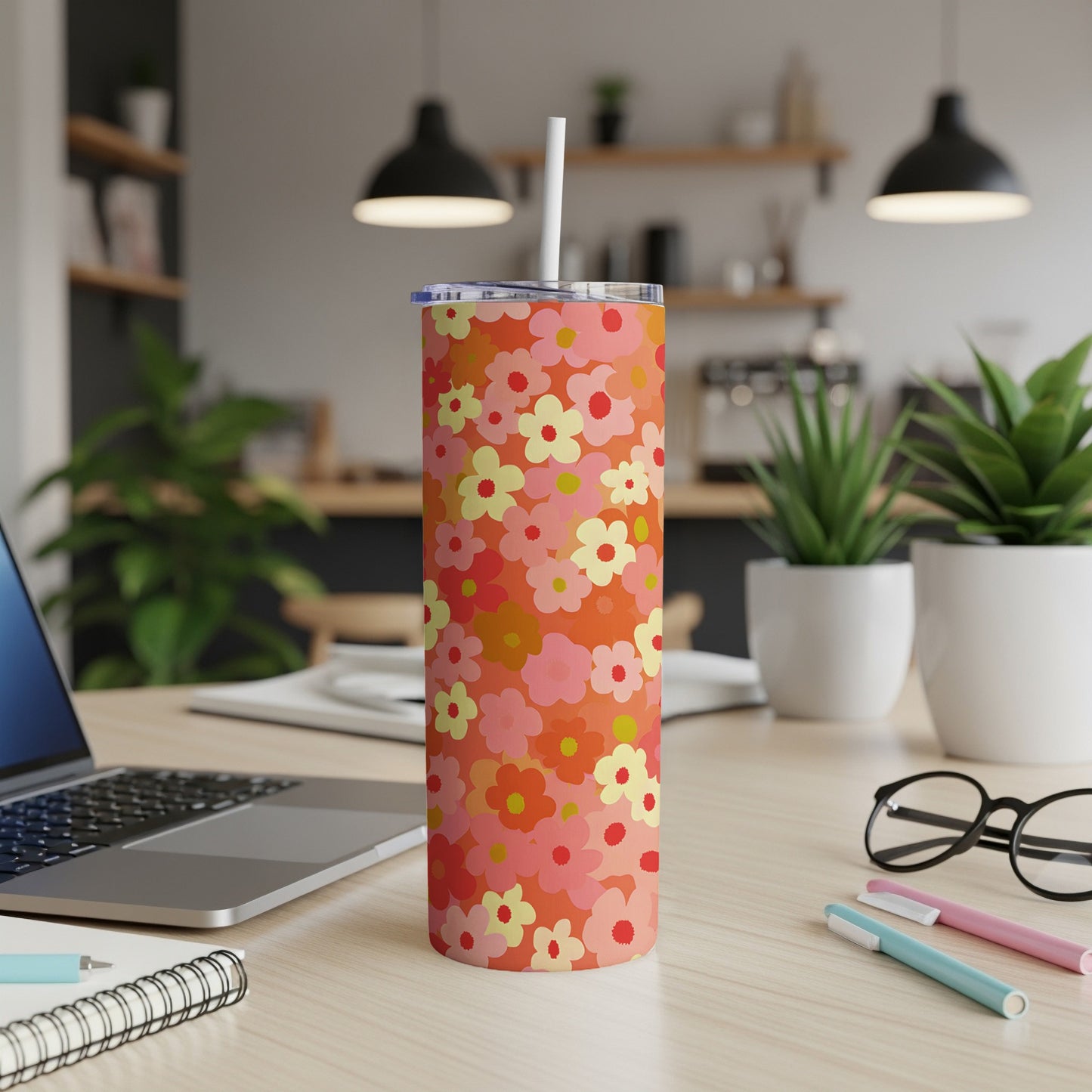 Orange tumbler with a floral pattern and white straw.