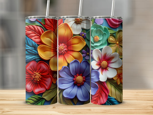 Three tumblers decorated with vibrant, textured floral patterns on a wooden surface.
