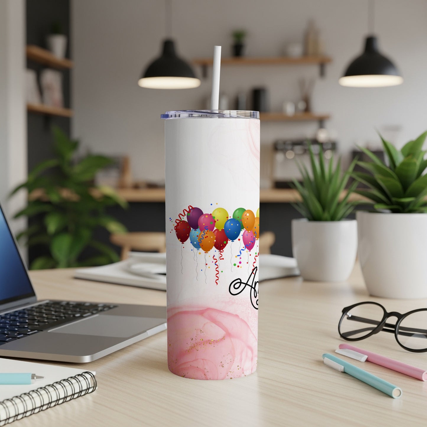 Tumbler with colorful balloons and "A" initial on a pink marble background.