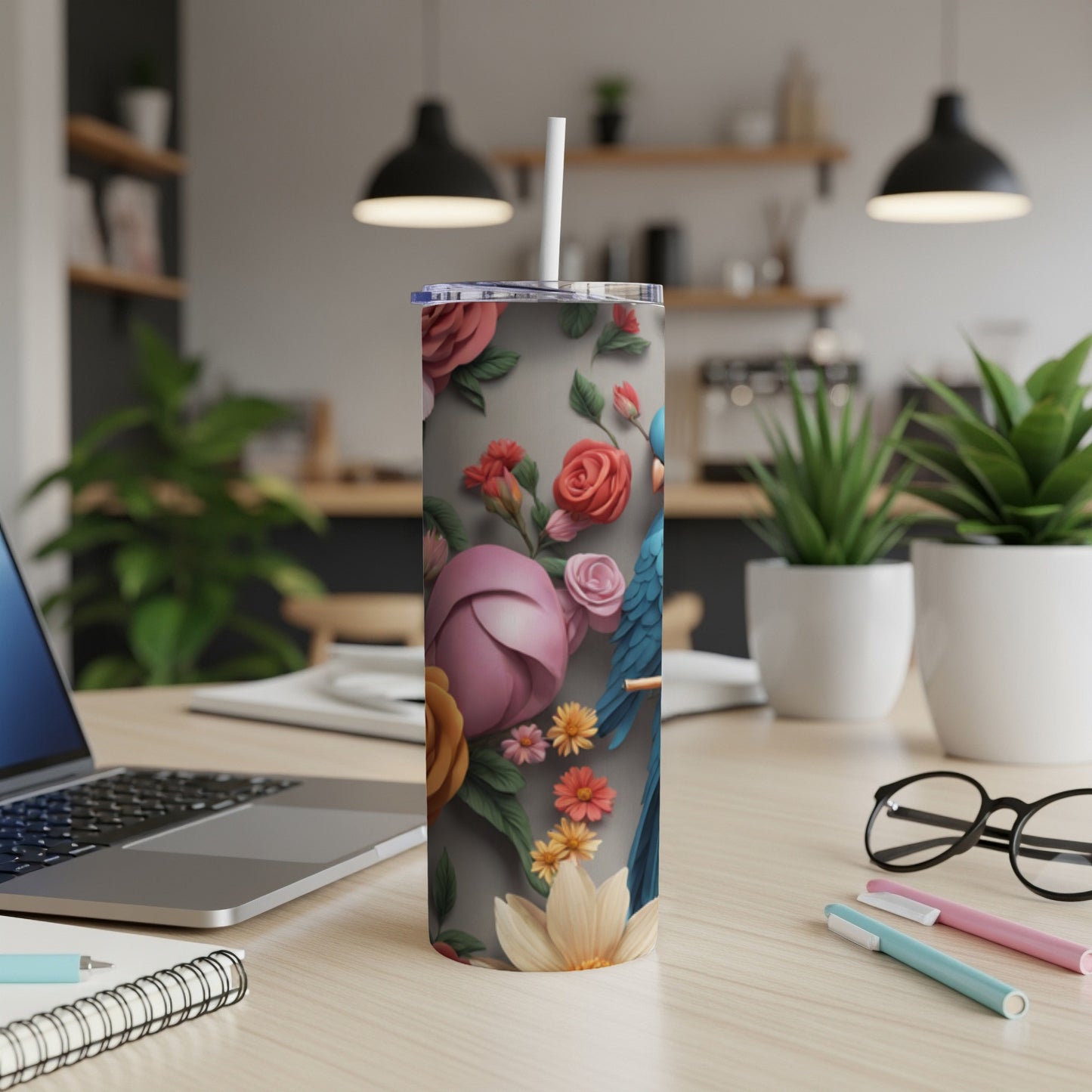 Floral patterned tumbler with a blue macaw, pink flowers, and green leaves.