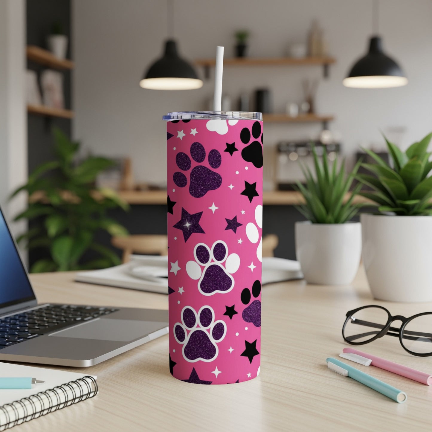 Pink tumbler with purple paw prints and glittery stars, straw inserted.