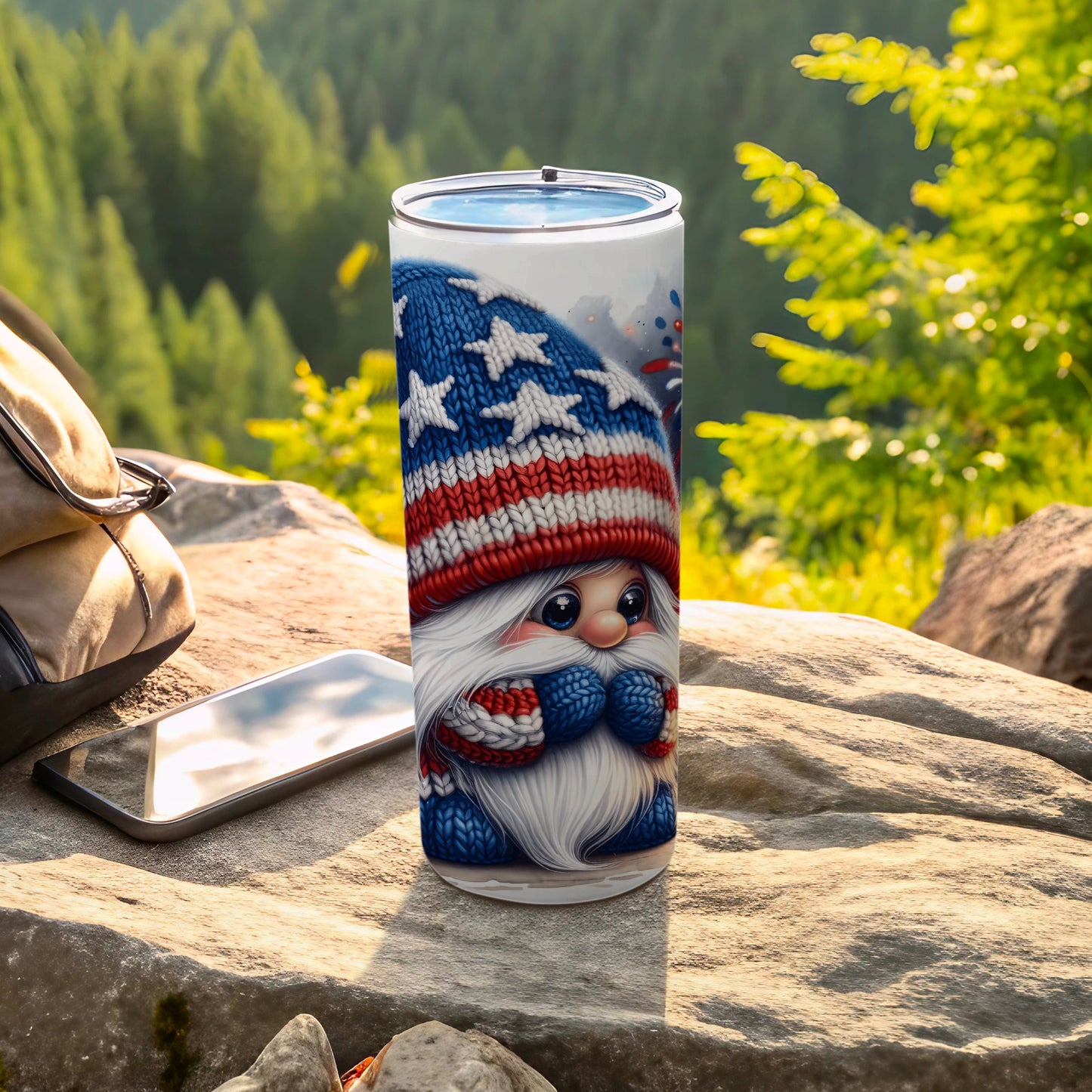 Gnome in patriotic hat and scarf on rocks with phone and backpack.