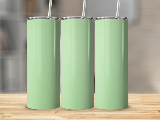Three mint green tumblers with white straws stand on a wooden surface.